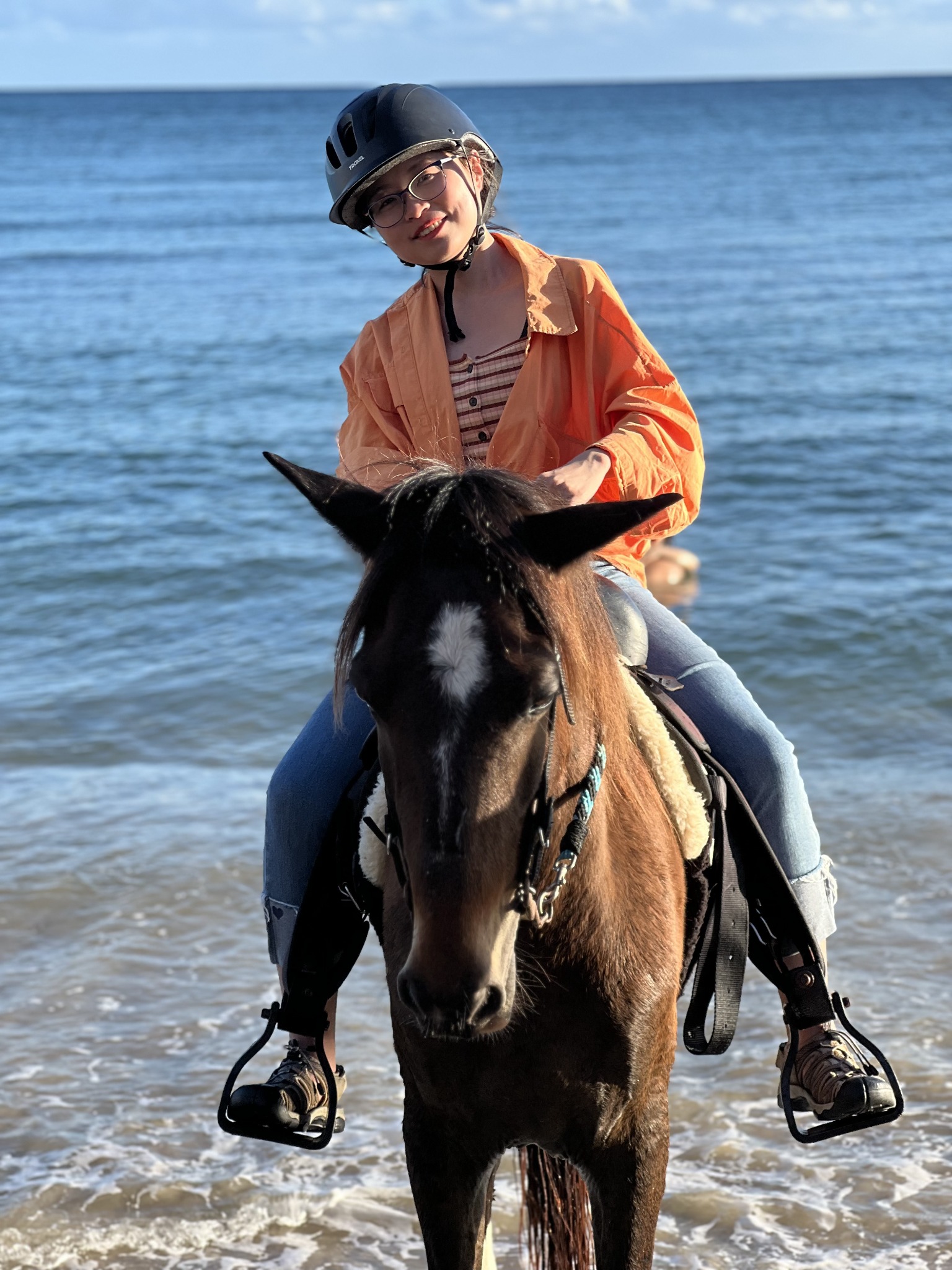 Yiping Wang riding a horse by the sea